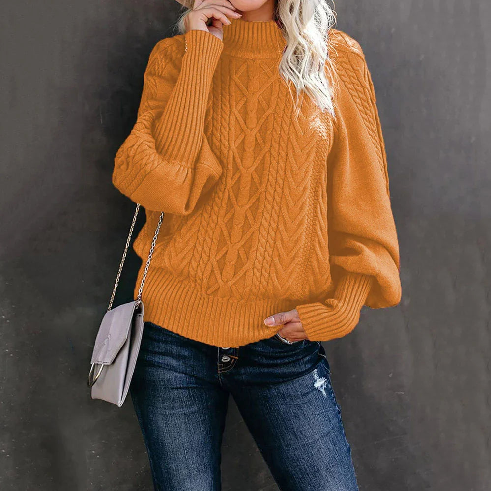 Woman wearing orange cable knit sweater with balloon sleeves and blue distressed jeans