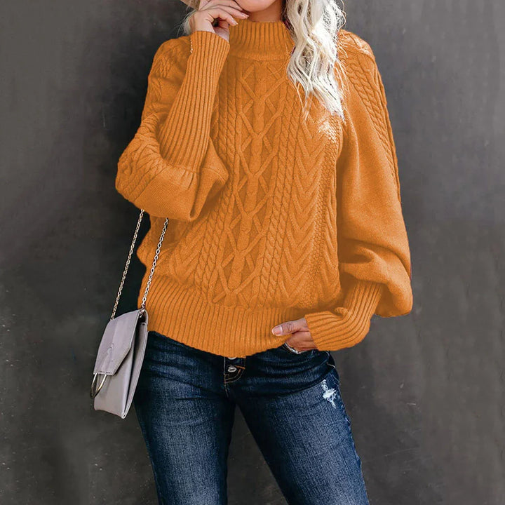 Woman wearing orange cable knit sweater with balloon sleeves and blue distressed jeans