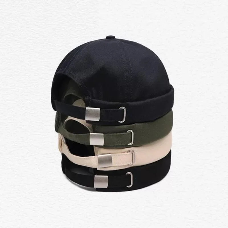 Stack of four adjustable beanie caps in black, olive green, beige, and black colors on white background