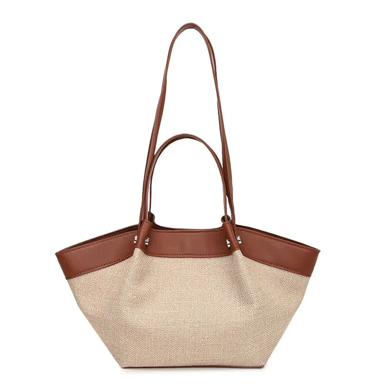 Beige canvas tote bag with brown leather trim and double handles, stylish everyday handbag