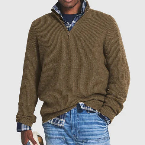 Man wearing brown ribbed half-zip sweater over blue plaid shirt with blue jeans