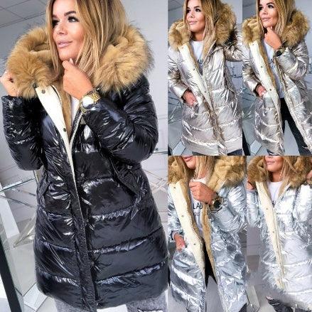 Woman modeling shiny black and silver puffer jackets with fur-trimmed hoods in indoor setting