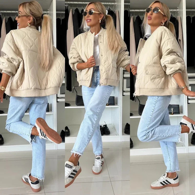 Woman wearing beige quilted jacket, white t-shirt, light blue jeans, and Adidas sneakers in closet setting