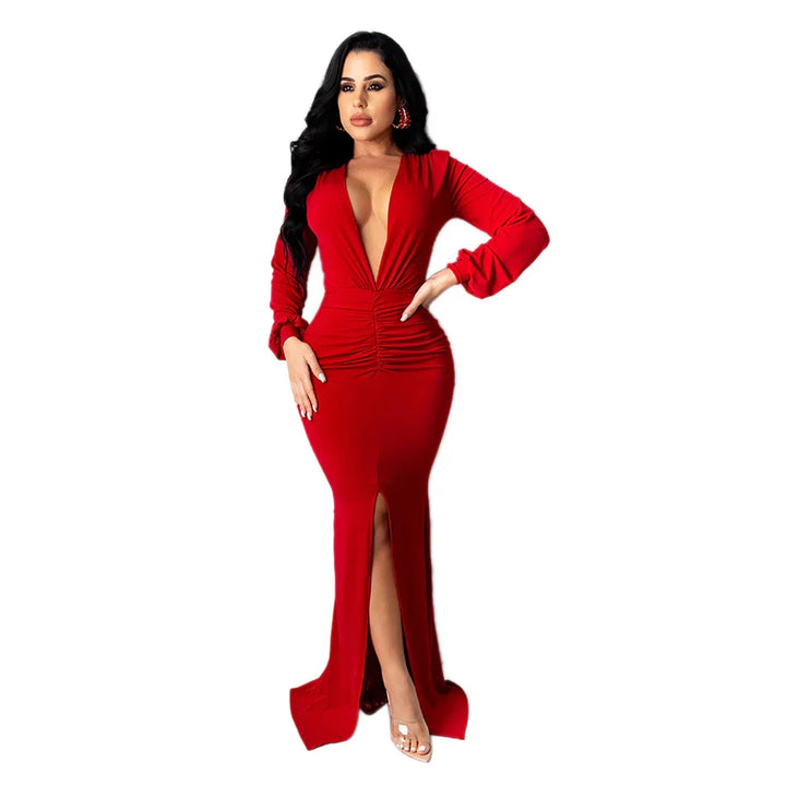 Woman in a long red dress with deep V-neck, ruched waist, front slit, and long sleeves