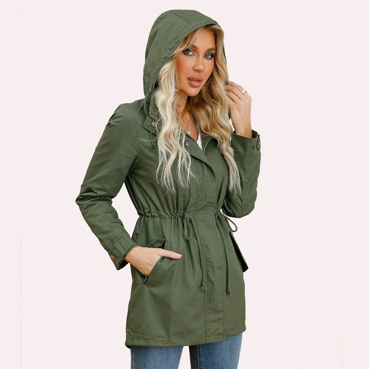 Blonde woman wearing an olive green hooded parka jacket with drawstring waist and front pockets