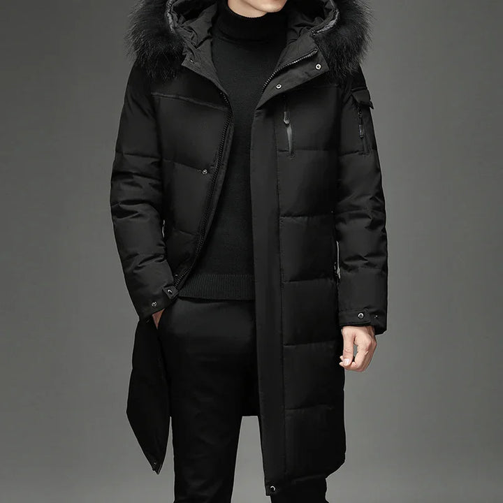 Man wearing a black long padded winter coat with a fur-trimmed hood and zippered pockets