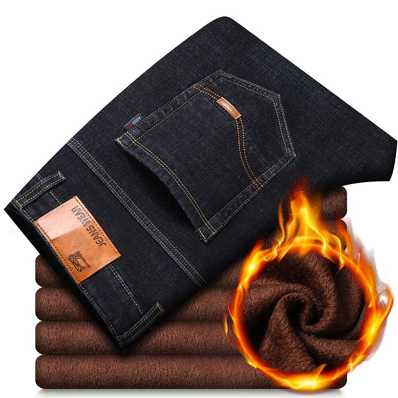 Folded dark blue jeans with leather patch labeled 'JEANS WEAR' on warm brown fleece fabric, flame effect