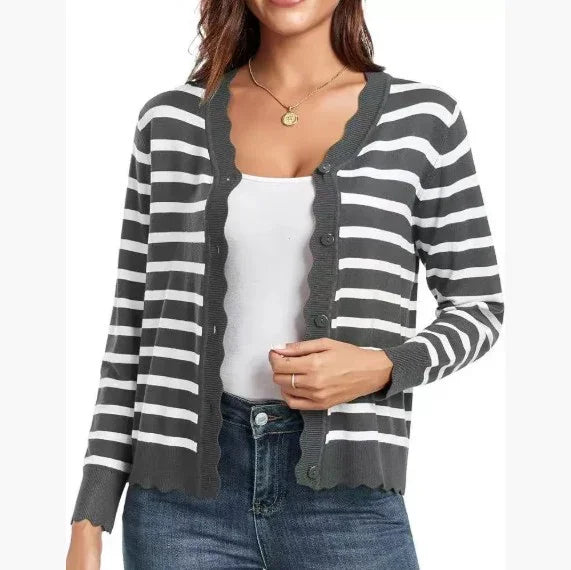 Woman wearing gray and white striped button-up cardigan with scalloped edges over white tank top and jeans