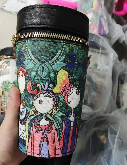 Colorful cylindrical bag with whimsical cartoon women and intricate green floral pattern, gold zipper detail
