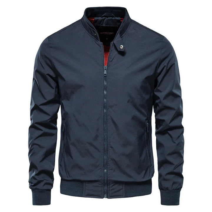 Men's navy blue bomber jacket with front zipper, stand collar, and zippered side pockets