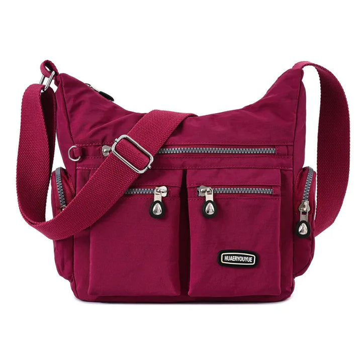 burgundy crossbody shoulder bag with adjustable strap and multiple zippered pockets