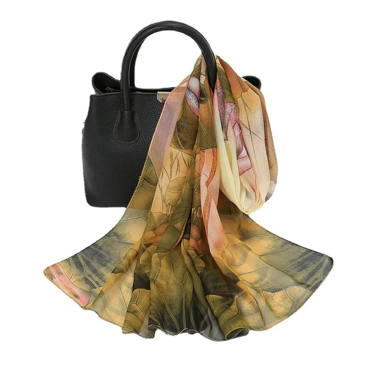 Black textured leather handbag with elegant floral patterned silk scarf draped over handle