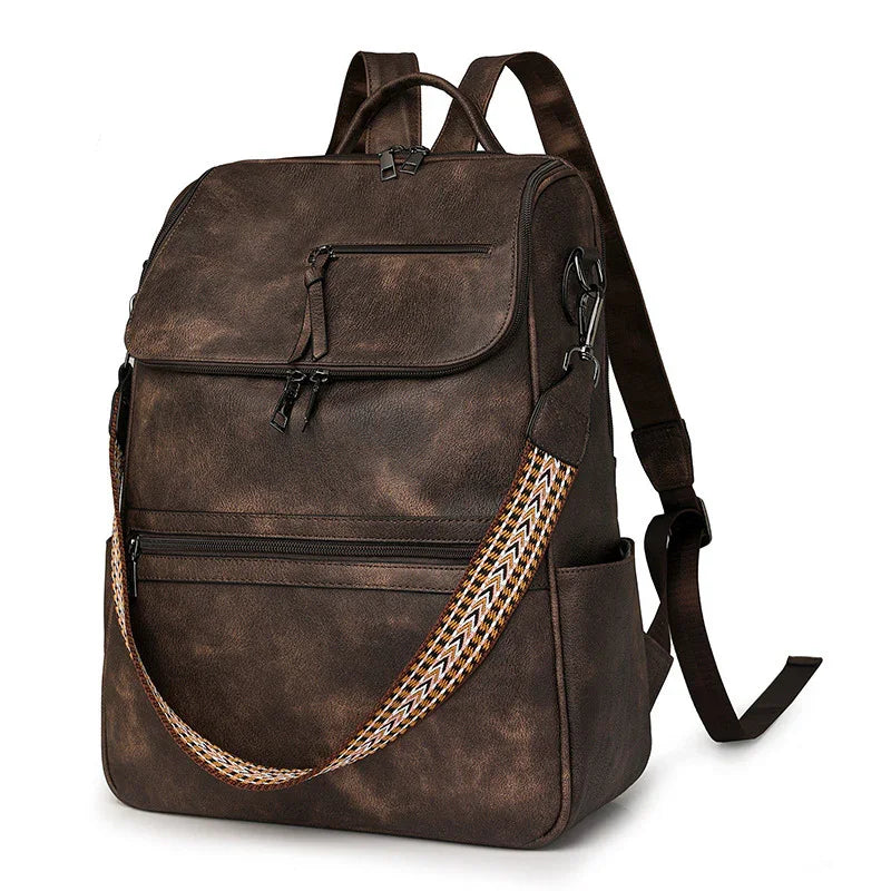 Vintage brown leather backpack with multiple zippered pockets and patterned shoulder strap
