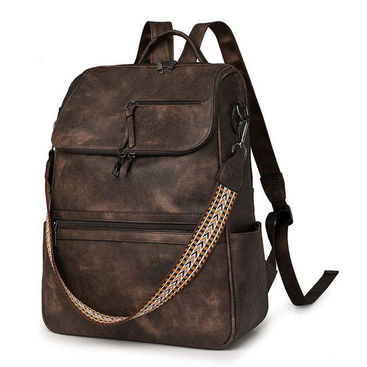 Vintage brown leather backpack with multiple zippered pockets and patterned shoulder strap