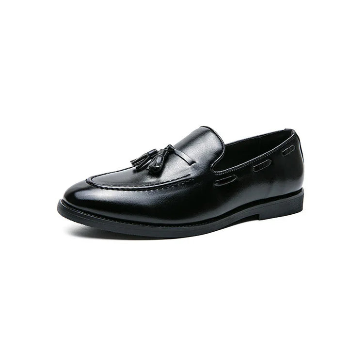 Black leather men's tassel loafer shoe with sleek design on white background