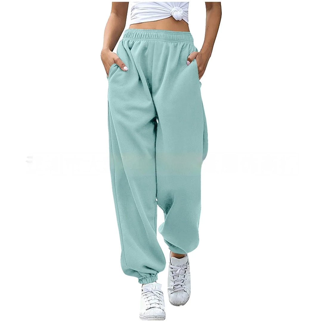 Woman wearing light teal loose jogger pants with elastic cuffs and white sneakers