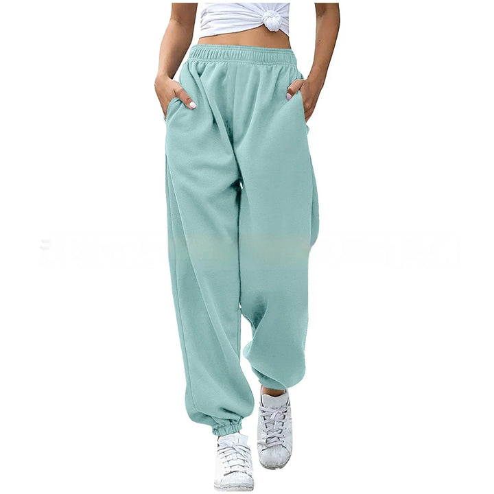Woman wearing light teal loose jogger pants with elastic cuffs and white sneakers