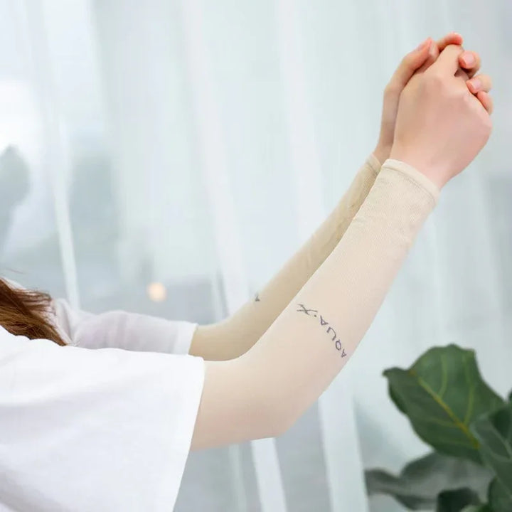 Person wearing beige AQUA-X sun protection arm sleeves with hands clasped upward indoors