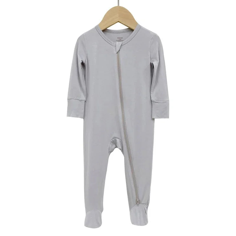 Light gray baby onesie with front diagonal zipper and footed legs on wooden hanger
