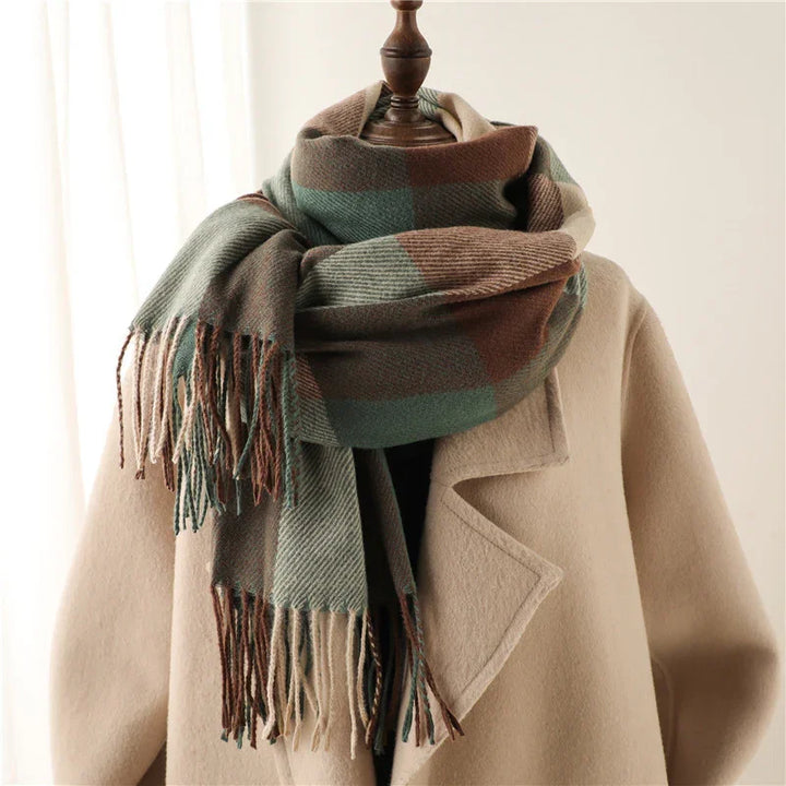 Beige wool coat on mannequin with green and brown checkered fringe scarf