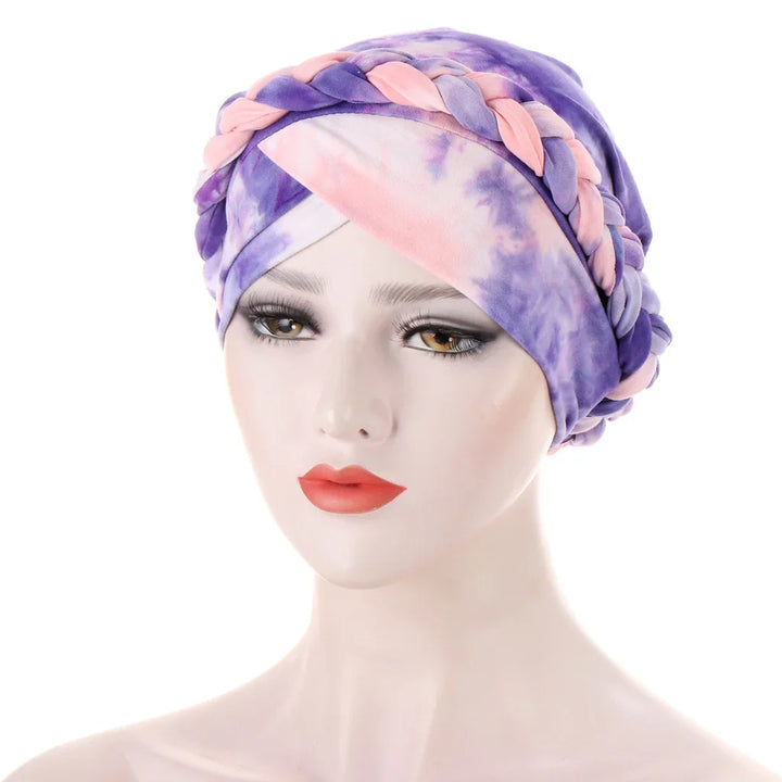 Woman mannequin wearing a purple and pink tie-dye braided turban headwrap