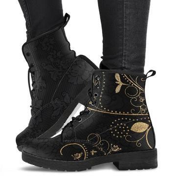 Black ankle boots with gold floral embroidery lace-up design worn with black pants