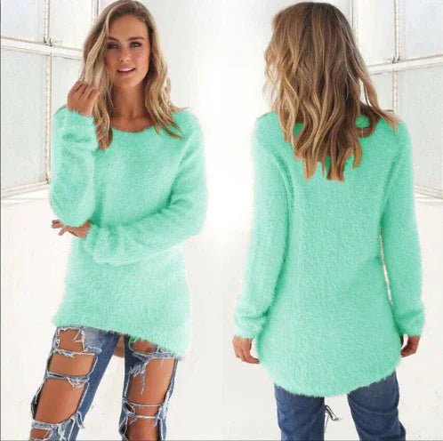 Woman wearing mint green fuzzy sweater paired with heavily ripped blue jeans in bright indoor setting