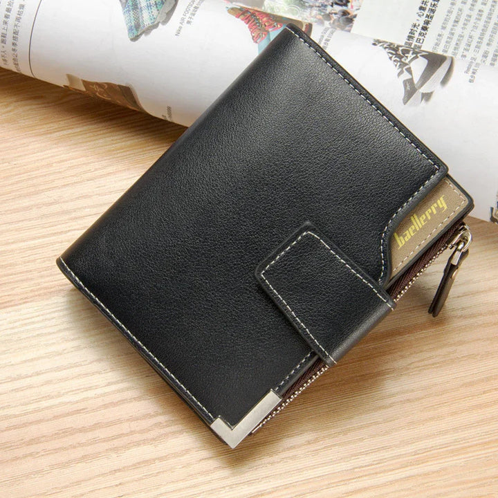 Black leather Baellerry wallet with zipper and snap closure on wooden surface with a rolled magazine