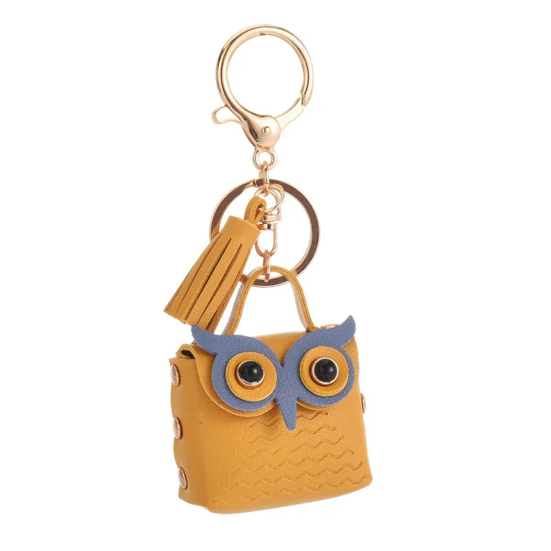 Yellow owl-shaped leather keychain with large eyes and tassel on gold clip ring