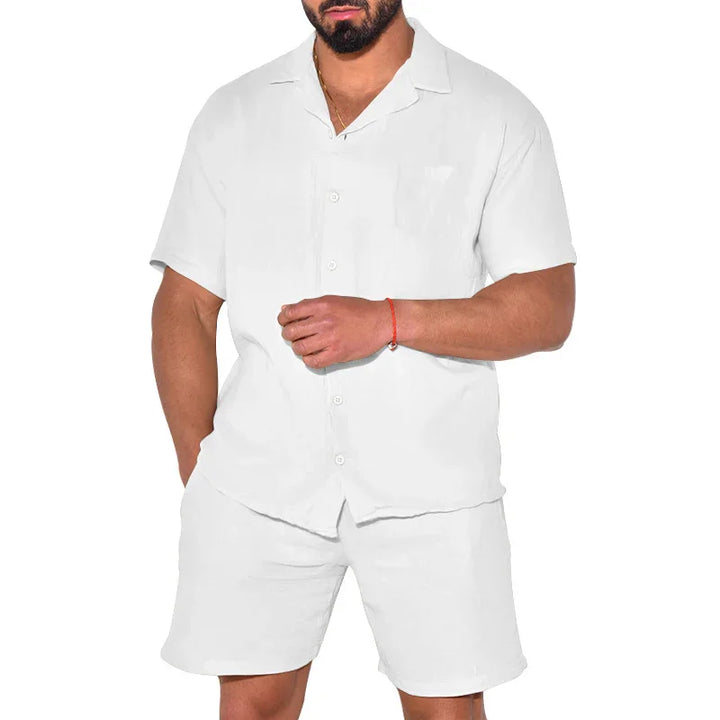 Man wearing white short-sleeve button-up shirt and matching white shorts isolated on white background