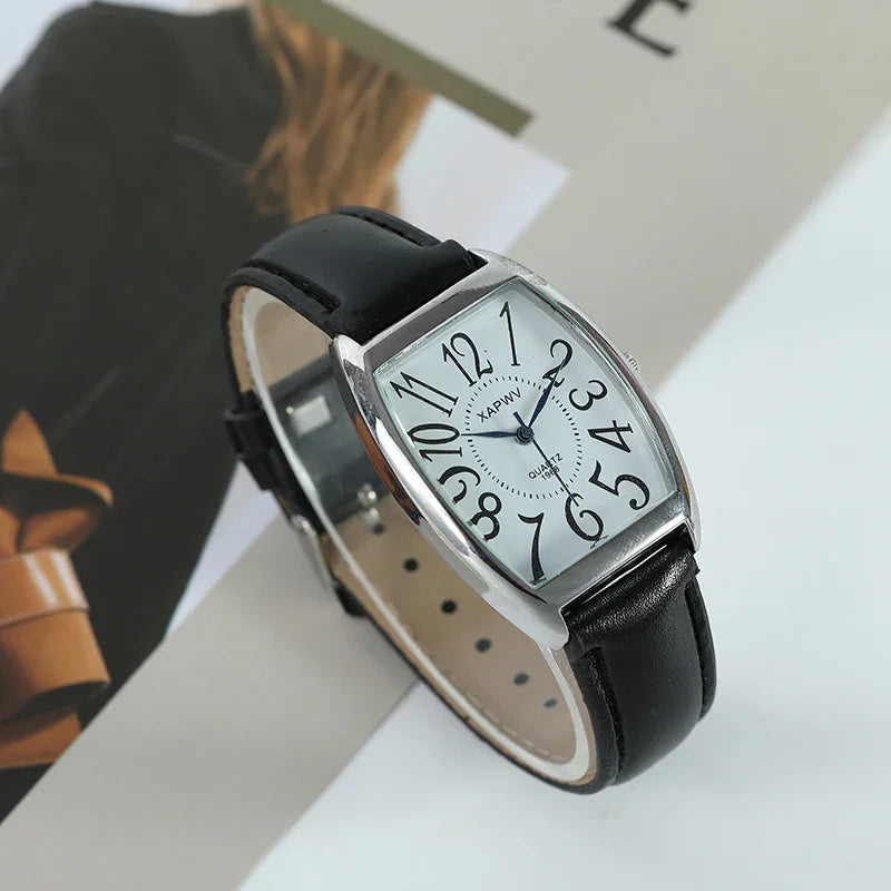 Silver wristwatch with black leather strap and distorted black numbers on white dial