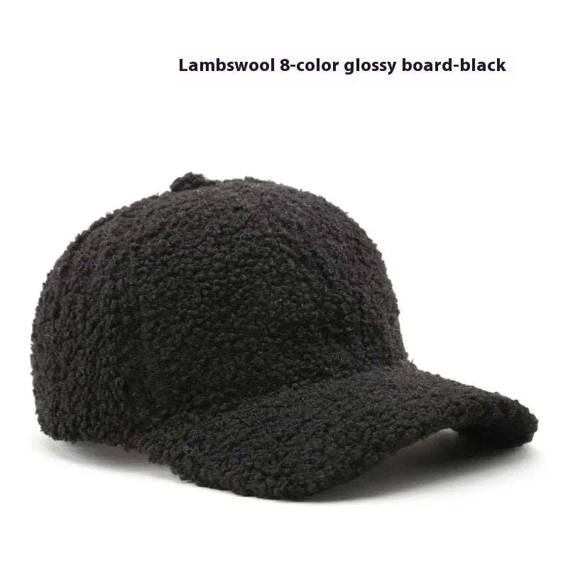 Black lambswool baseball cap with textured, curly fabric and curved brim on white background