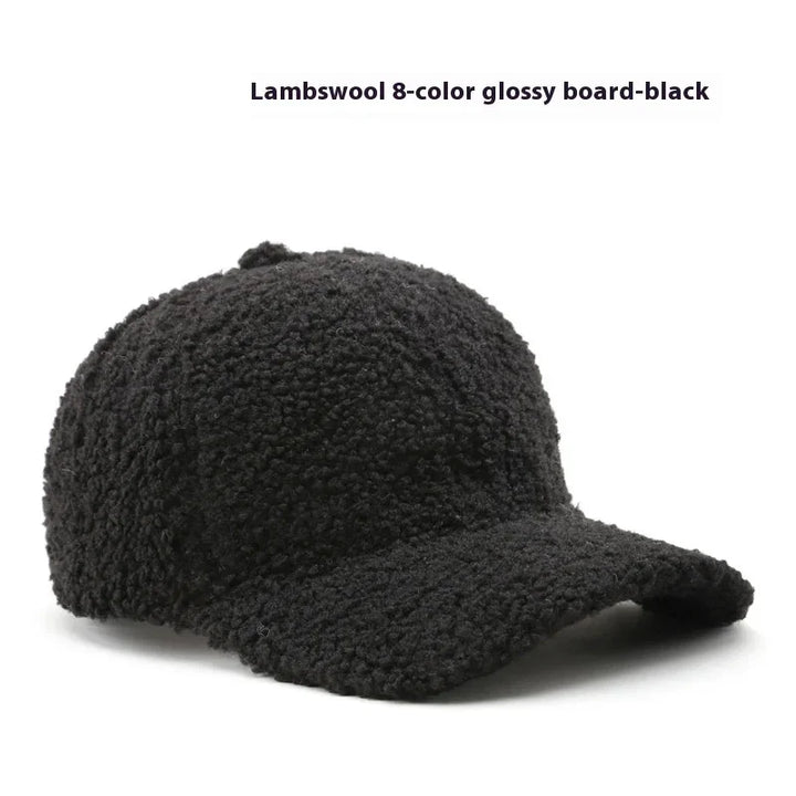 Black lambswool baseball cap with textured, curly fabric and curved brim on white background
