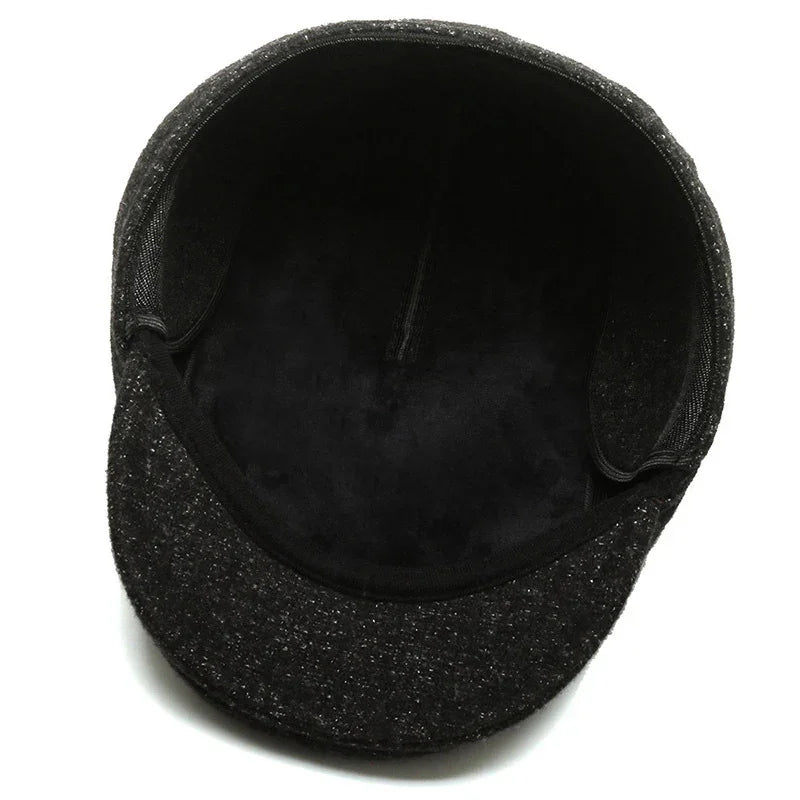 Inside view of a black textured flat cap with soft lining and structured brim