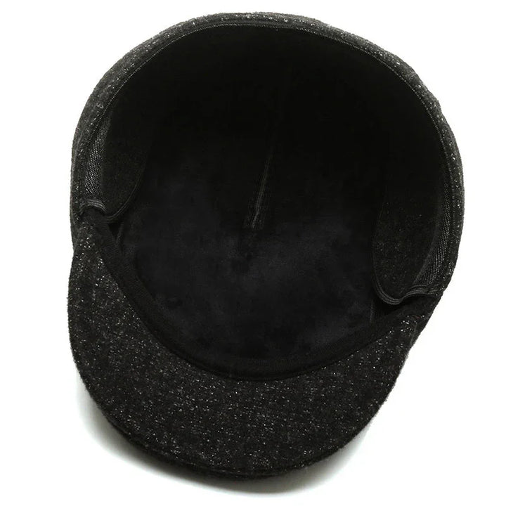Inside view of a black textured flat cap with soft lining and structured brim