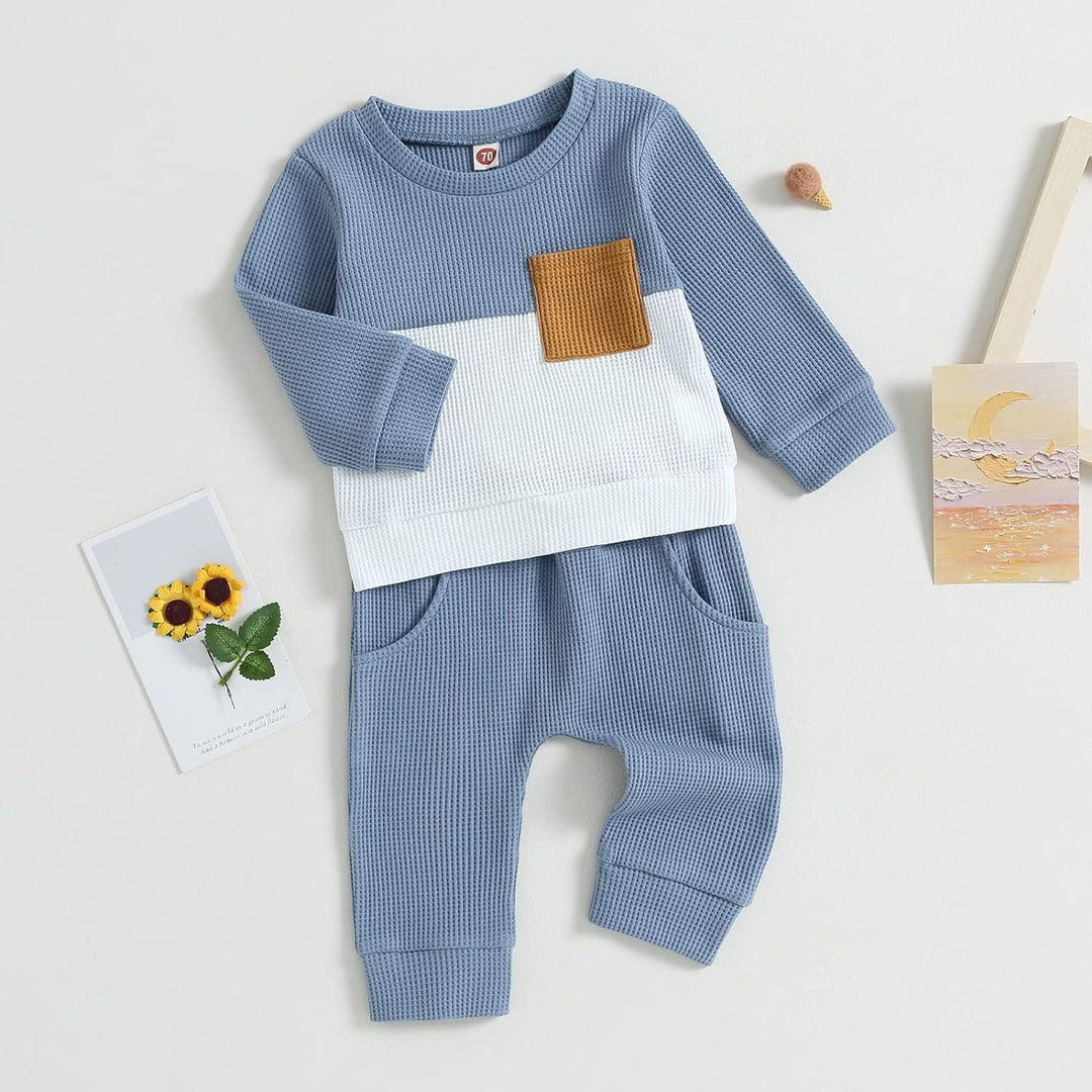 Blue and white textured baby outfit with long sleeves and brown chest pocket