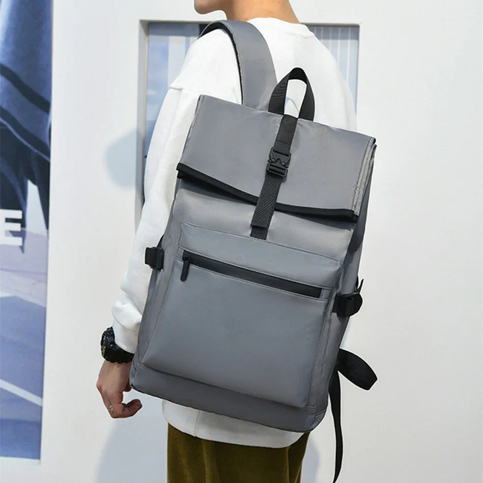 Person wearing a modern gray backpack with black buckle and front zipper pocket