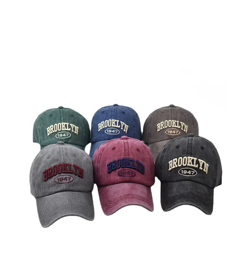 Six vintage-style baseball caps in green, blue, brown, gray, burgundy, and black with Brooklyn 1947 embroidery