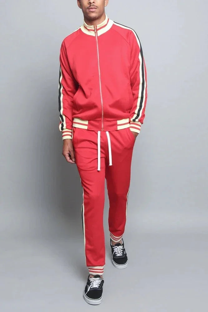 Man wearing red track suit with white and black side stripes, sporty streetwear outfit