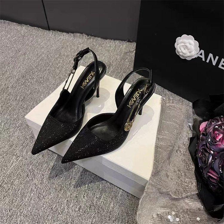 Black glitter slingback stiletto heels on white box with floral and Chanel shopping bag background