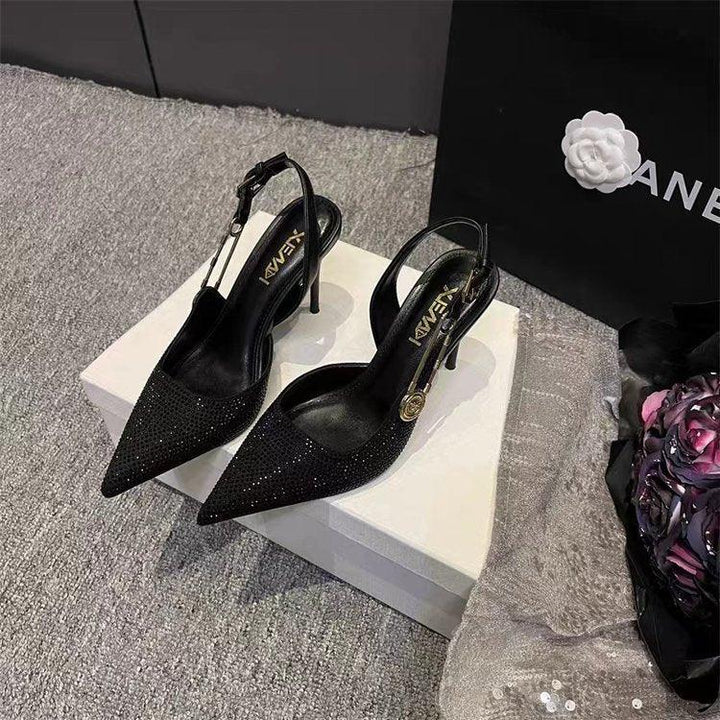 Black glitter slingback stiletto heels on white box with floral and Chanel shopping bag background