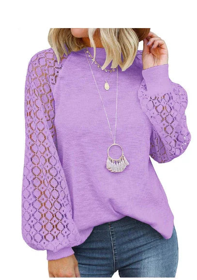 Woman wearing lavender sweater with lace puff sleeves and layered gold necklaces