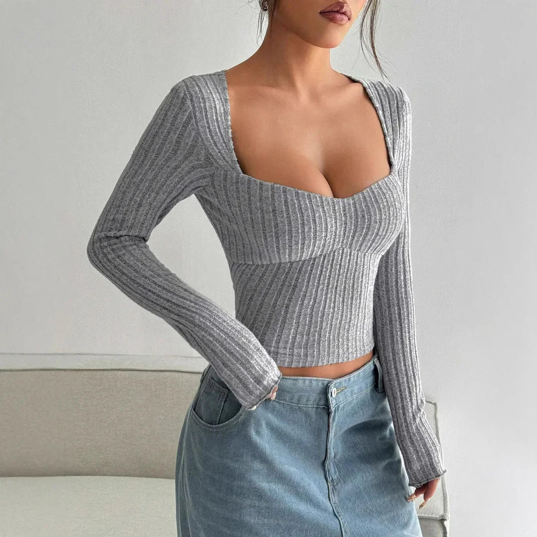 Woman wearing fitted ribbed grey long sleeve crop top with square neckline and light blue denim skirt