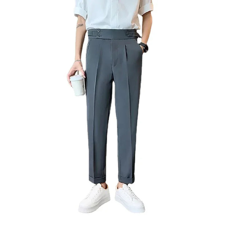 Modern slim-fit gray dress pants with cuffed hems, worn with white sneakers and holding a coffee cup