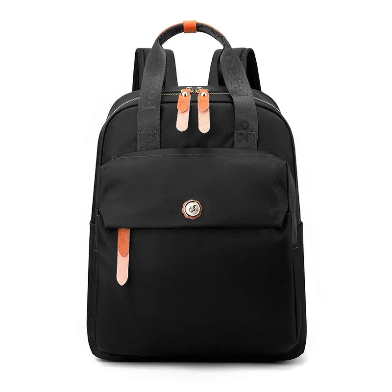 black backpack with dual zippers, front pocket flap, leather accents, and branded straps