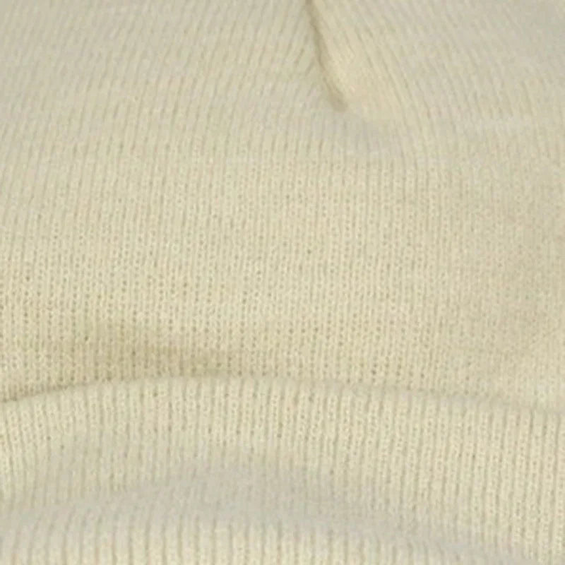 Close-up of beige knitted wool fabric showcasing soft texture and fine stitching