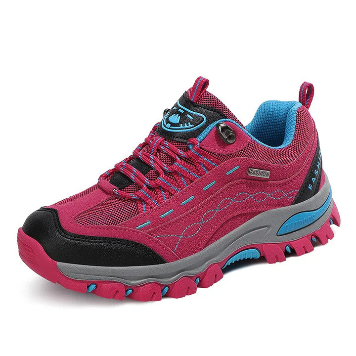 Pink and black outdoor hiking shoe with blue accents and rugged sole for trail walking