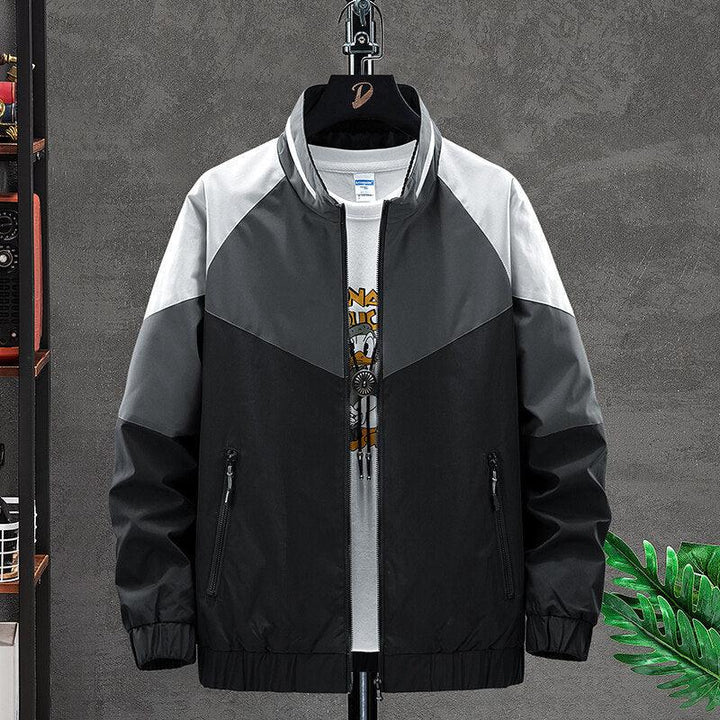Men's colorblock bomber jacket in black, gray, and white with zippered pockets over graphic tee