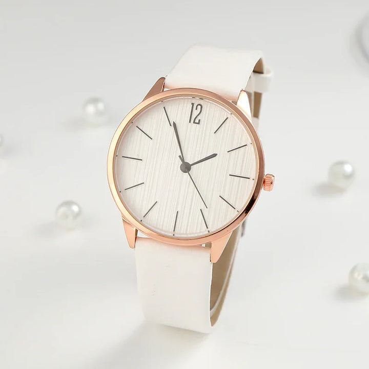 Elegant rose gold wristwatch with white leather strap and minimalist white textured dial