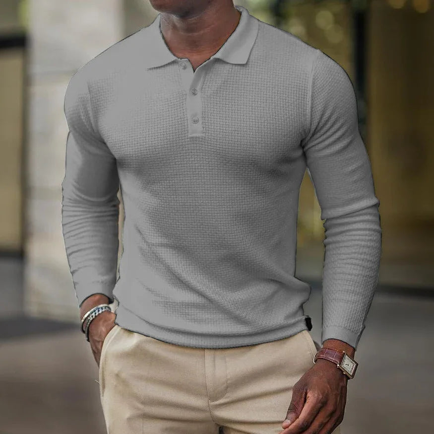 Man wearing fitted gray long-sleeve polo shirt and beige pants with watch and bracelet